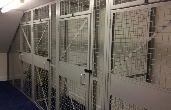 Mesh security storage cages in a room with a sloping roof at a residential apartment development to store property