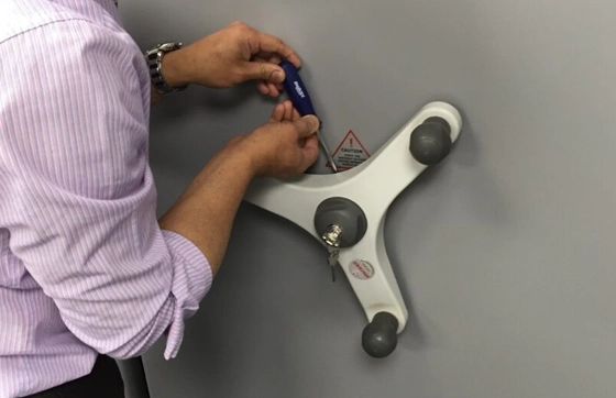 A Storwell Systems Engineer adjusting rotary hand wheel on mobile shelving system with screwdriver