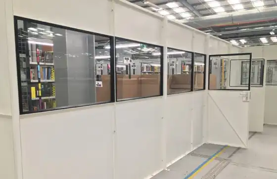 Close-up of office using single skin steel partitioning with half-glased panels separating it within a distribution warehouse